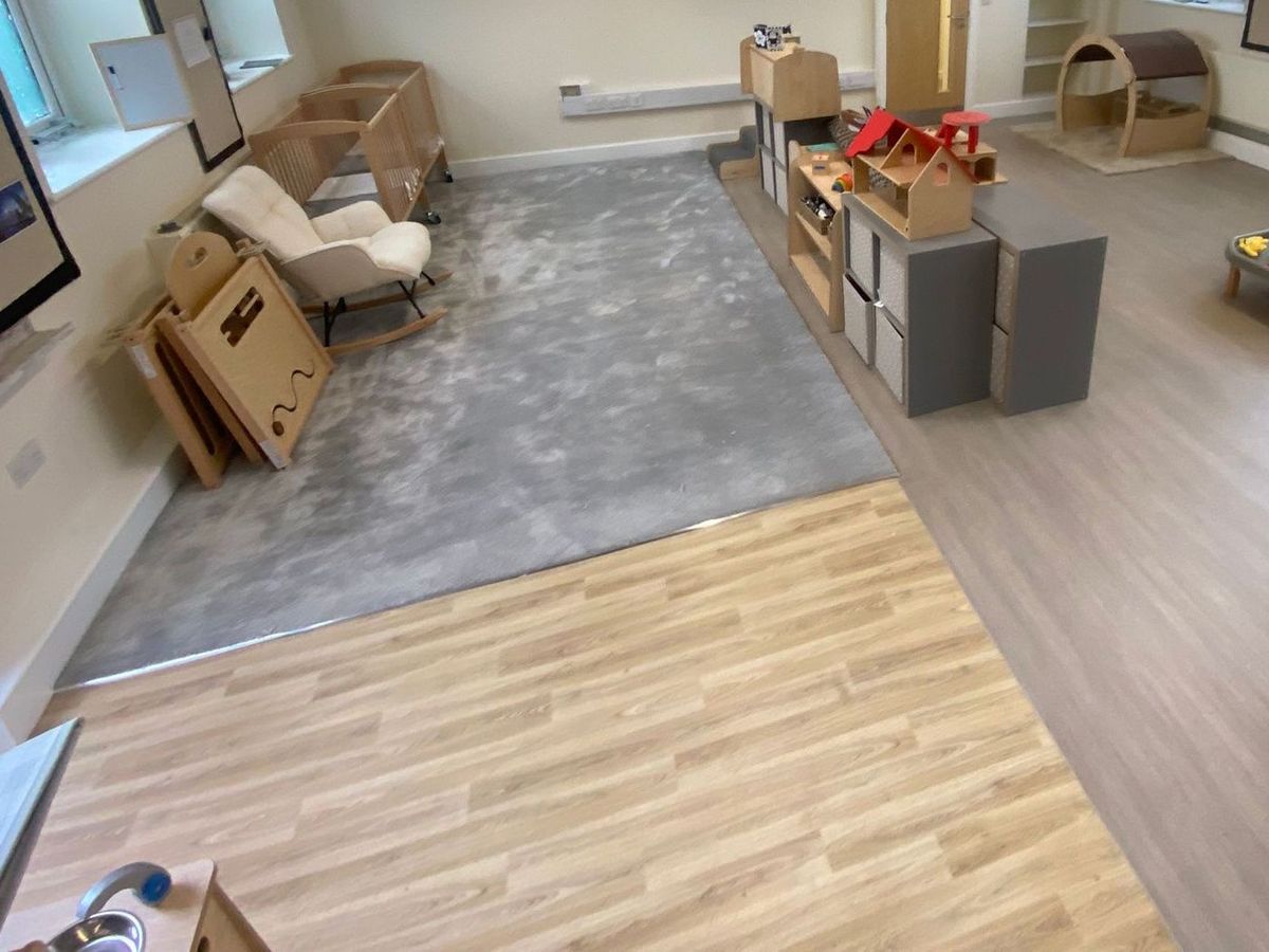 Grey carpet area meeting light oak-effect flooring and grey wood-effect vinyl