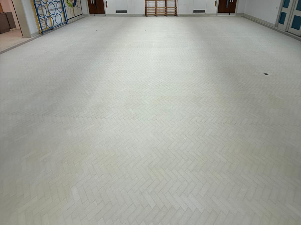 Herringbone Granwood block floor in a hall, sanded and not yet sealed, with a pale matt finish