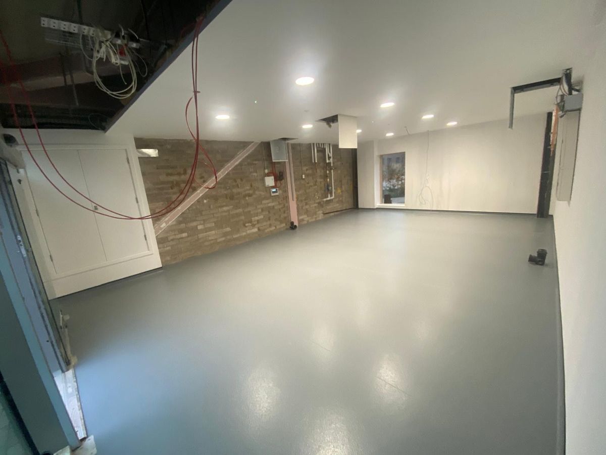 Empty room with a smooth, seamless grey floor running to the walls
