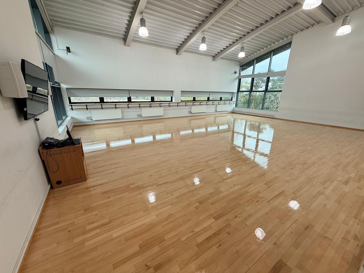 Large hall with a glossy strip hardwood floor after sanding and sealing