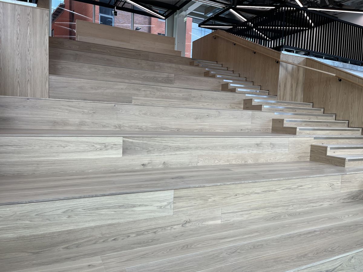 Wide tiered oak hardwood steps with a stair flight to one side