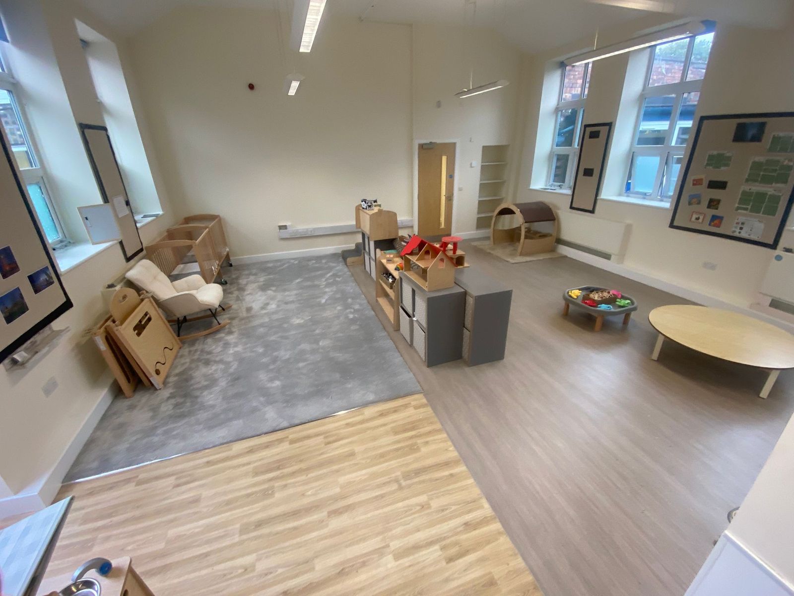 Room with an area of grey carpet, light oak-effect flooring and grey wood-effect vinyl, with neat transitions where the floors meet